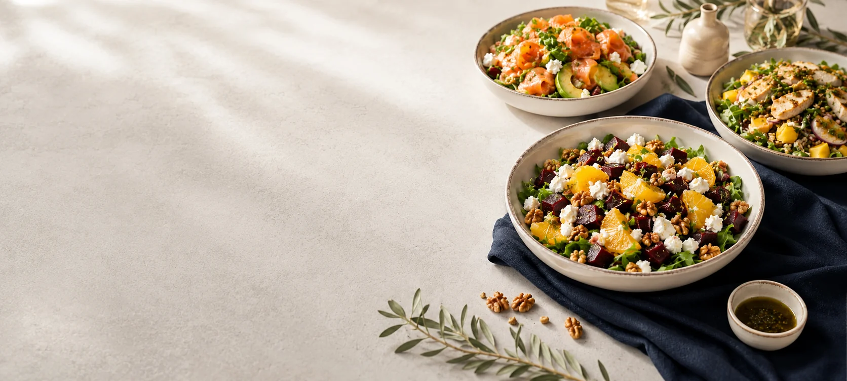 Fresh salads and nourishing bowls on a light stone table